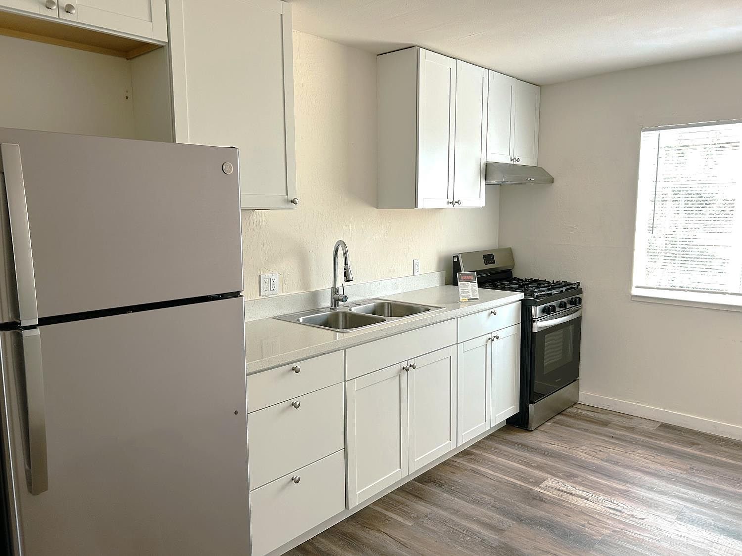Renovated kitchen with white shaker cabinets and stainless appliances