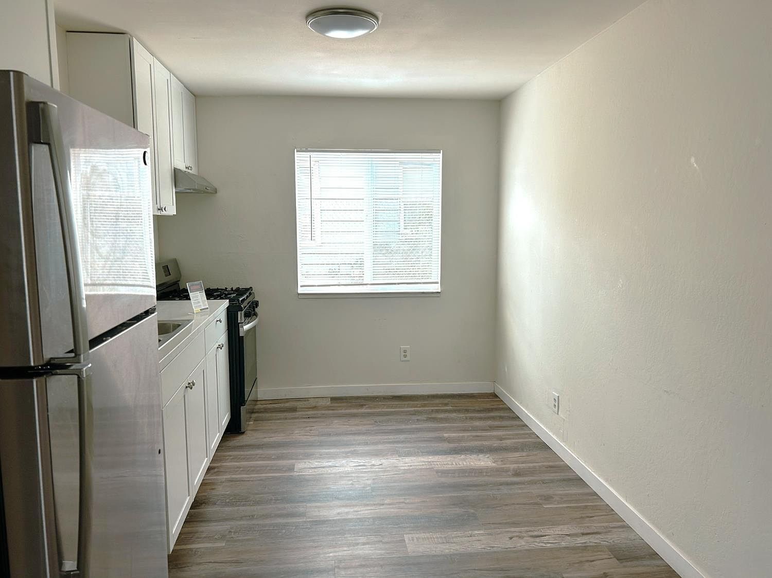 Galley kitchen with stainless refrigerator and gas range