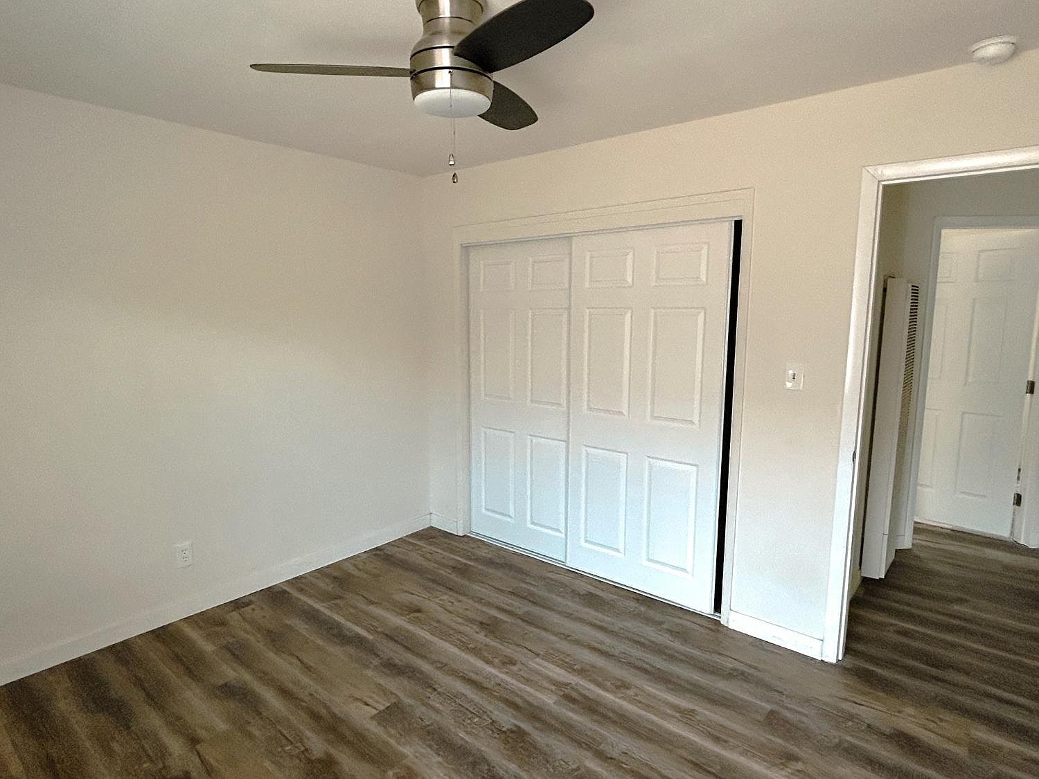 Bedroom with sliding closet doors and new flooring