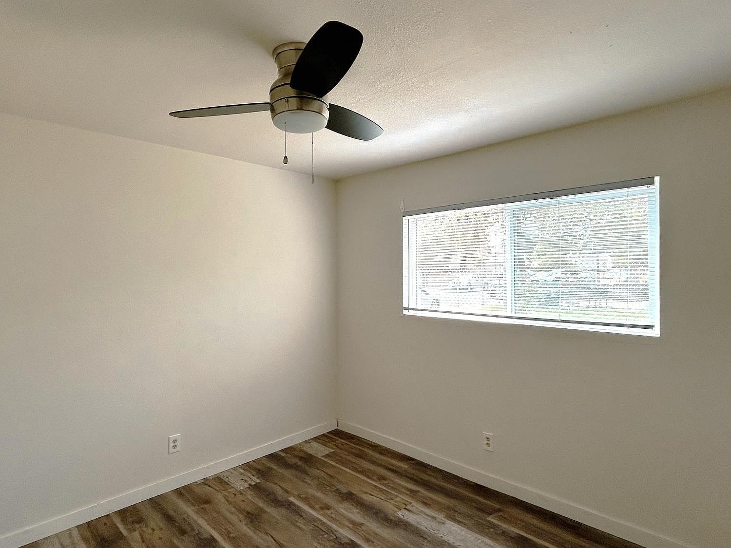 Bedroom with ceiling fan and large window