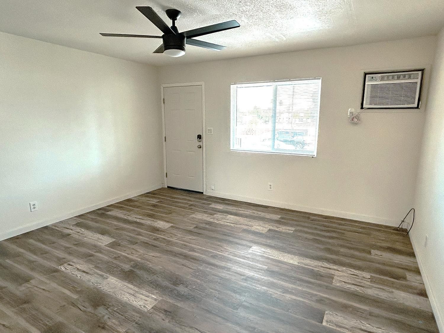 Living room with ceiling fan and wall air conditioner
