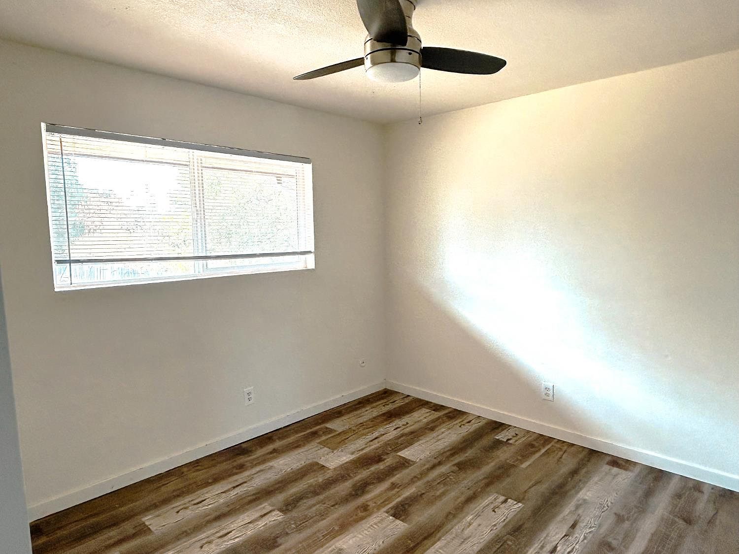 Bedroom with large window and ceiling fan