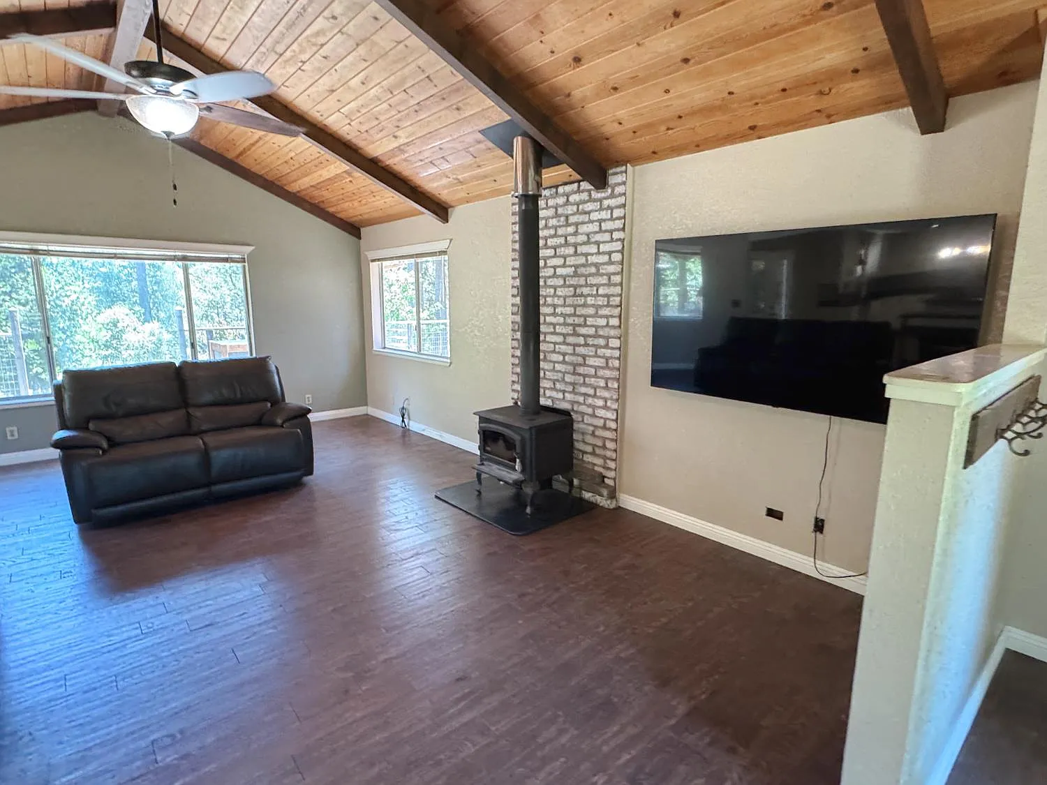 Open-plan living room under the vaulted wood ceiling looking through to the kitchen