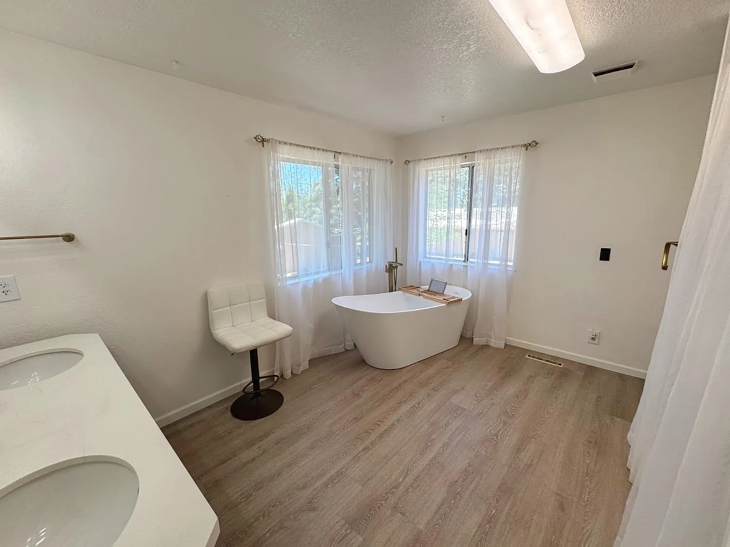 Bathroom with freestanding soaking tub, double vanity and large window
